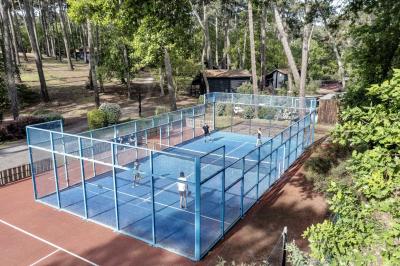 Bar animé avec des lumières colorées, des clients discutant et des paniers suspendus en décoration.