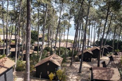 Bar animé avec des lumières colorées, des clients discutant et des paniers suspendus en décoration.