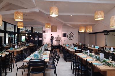 Bar animé avec des lumières colorées, des clients discutant et des paniers suspendus en décoration.