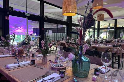 Bar animé avec des lumières colorées, des clients discutant et des paniers suspendus en décoration.