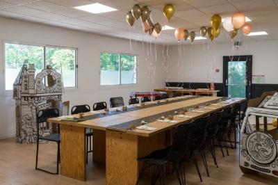 Bar animé avec des lumières colorées, des clients discutant et des paniers suspendus en décoration.