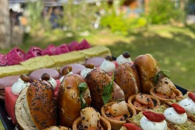 Salle de réception décorée avec des tables rondes, nappes blanches, serviettes orange et chaises blanches.
