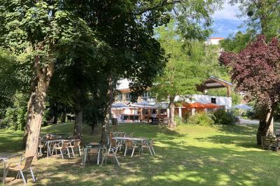 Salle de réception décorée avec des tables rondes, nappes blanches, serviettes orange et chaises blanches.