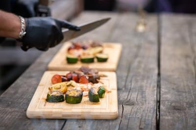 Salle de réception décorée avec des tables rondes, nappes blanches, serviettes orange et chaises blanches.