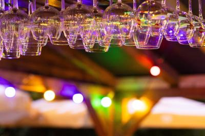 Salle de réception décorée avec des tables rondes, nappes blanches, serviettes orange et chaises blanches.