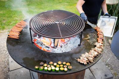 Salle de réception décorée avec des tables rondes, nappes blanches, serviettes orange et chaises blanches.