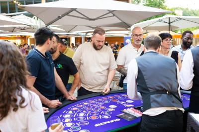 Salle de réception décorée avec des tables rondes, nappes blanches, serviettes orange et chaises blanches.