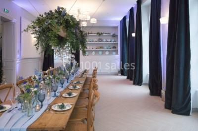 Buffet de petit-déjeuner avec viennoiseries, pain, confiture et grille-pain, devant une fenêtre et des fleurs décoratives.