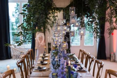 Buffet de petit-déjeuner avec viennoiseries, pain, confiture et grille-pain, devant une fenêtre et des fleurs décoratives.
