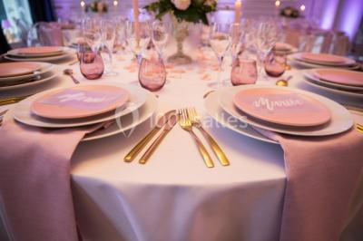 Buffet de petit-déjeuner avec viennoiseries, pain, confiture et grille-pain, devant une fenêtre et des fleurs décoratives.