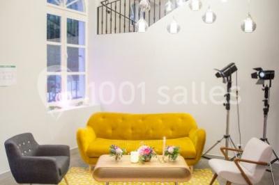 Buffet de petit-déjeuner avec viennoiseries, pain, confiture et grille-pain, devant une fenêtre et des fleurs décoratives.