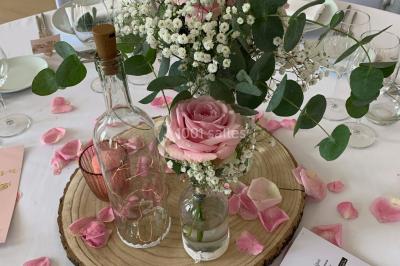Buffet de petit-déjeuner avec viennoiseries, pain, confiture et grille-pain, devant une fenêtre et des fleurs décoratives.