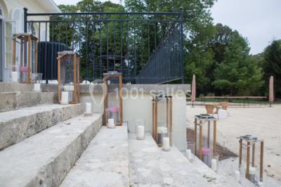 Véhicule tout-terrain rouge stationné sur des marches en pierre devant un bâtiment avec de grandes fenêtres.