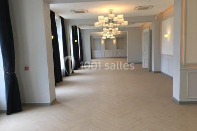 Véhicule tout-terrain rouge stationné sur des marches en pierre devant un bâtiment avec de grandes fenêtres.