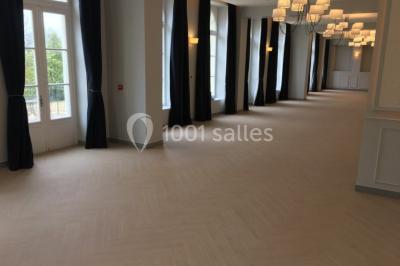 Véhicule tout-terrain rouge stationné sur des marches en pierre devant un bâtiment avec de grandes fenêtres.