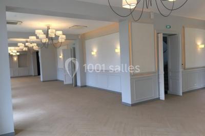 Véhicule tout-terrain rouge stationné sur des marches en pierre devant un bâtiment avec de grandes fenêtres.