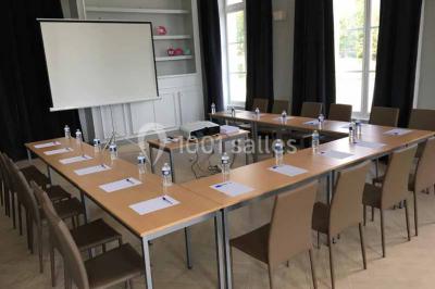 Véhicule tout-terrain rouge stationné sur des marches en pierre devant un bâtiment avec de grandes fenêtres.