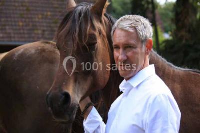 Véhicule tout-terrain rouge stationné sur des marches en pierre devant un bâtiment avec de grandes fenêtres.