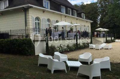 Véhicule tout-terrain rouge stationné sur des marches en pierre devant un bâtiment avec de grandes fenêtres.