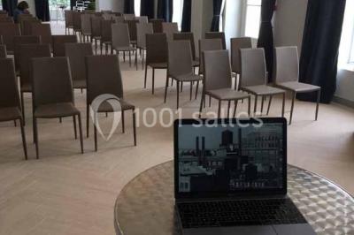 Véhicule tout-terrain rouge stationné sur des marches en pierre devant un bâtiment avec de grandes fenêtres.