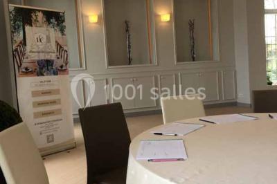 Véhicule tout-terrain rouge stationné sur des marches en pierre devant un bâtiment avec de grandes fenêtres.