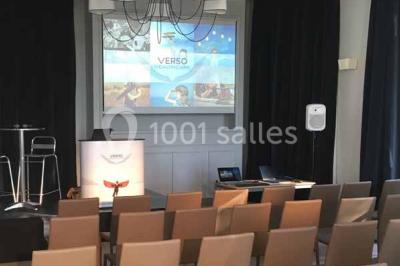 Véhicule tout-terrain rouge stationné sur des marches en pierre devant un bâtiment avec de grandes fenêtres.