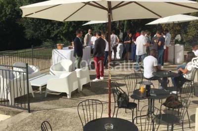 Véhicule tout-terrain rouge stationné sur des marches en pierre devant un bâtiment avec de grandes fenêtres.