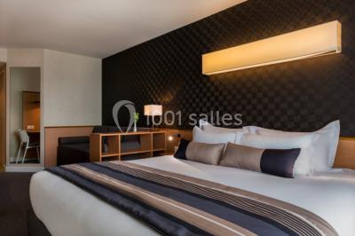 Salle de restaurant lumineuse avec des tables en bois, chaises bleues et grandes fenêtres laissant entrer la lumière…