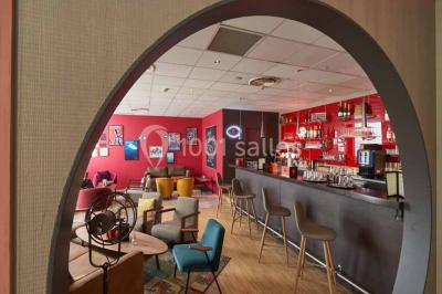 Salle de restaurant lumineuse avec des tables en bois, chaises bleues et grandes fenêtres laissant entrer la lumière…