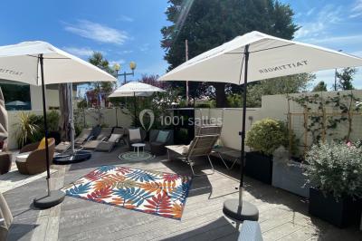Salle de restaurant lumineuse avec des tables en bois, chaises bleues et grandes fenêtres laissant entrer la lumière…