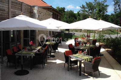 Lit double avec tête de lit décorative, coussins beige et bleu, tables de chevet avec lampes et décoration murale.