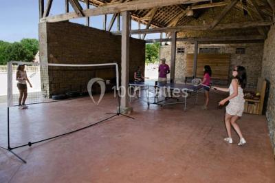 Lit double avec tête de lit décorative, coussins beige et bleu, tables de chevet avec lampes et décoration murale.
