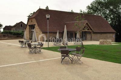 Lit double avec tête de lit décorative, coussins beige et bleu, tables de chevet avec lampes et décoration murale.