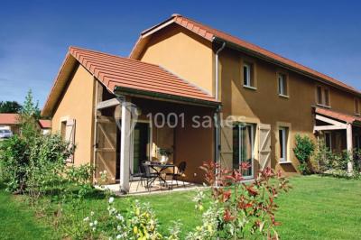 Lit double avec tête de lit décorative, coussins beige et bleu, tables de chevet avec lampes et décoration murale.