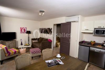 Lit double avec tête de lit décorative, coussins beige et bleu, tables de chevet avec lampes et décoration murale.