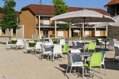 Lit double avec tête de lit décorative, coussins beige et bleu, tables de chevet avec lampes et décoration murale.