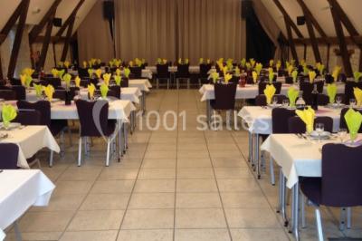 Lit double avec tête de lit décorative, coussins beige et bleu, tables de chevet avec lampes et décoration murale.