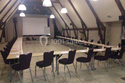 Lit double avec tête de lit décorative, coussins beige et bleu, tables de chevet avec lampes et décoration murale.