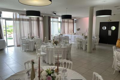 Allée avec tapis rouge menant à une arche décorée de fleurs, dans un espace extérieur ensoleillé.