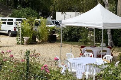 Allée avec tapis rouge menant à une arche décorée de fleurs, dans un espace extérieur ensoleillé.