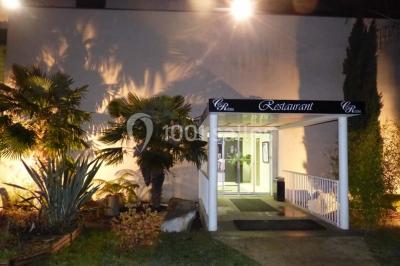 Allée avec tapis rouge menant à une arche décorée de fleurs, dans un espace extérieur ensoleillé.