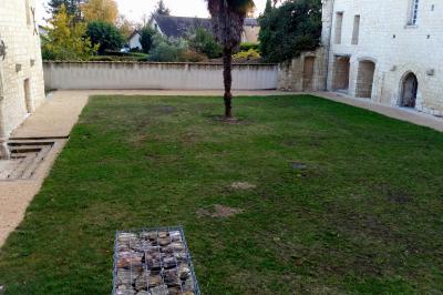 Salle avec des chaises rouges alignées, une table avec des micros, un écran de projection et des bannières promotionnelles.
