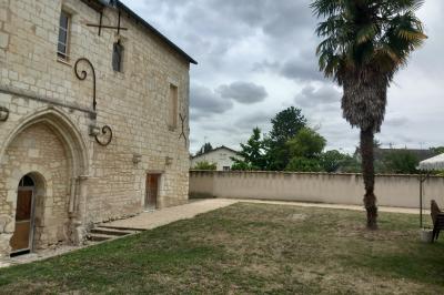 Salle avec des chaises rouges alignées, une table avec des micros, un écran de projection et des bannières promotionnelles.