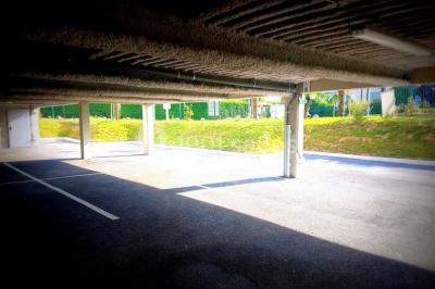 Salle de jeux lumineuse avec une cabane en tissu, un tapis de chiffres, une cuisine pour enfants et des tables colorées.