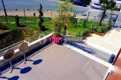 Salle de jeux lumineuse avec une cabane en tissu, un tapis de chiffres, une cuisine pour enfants et des tables colorées.