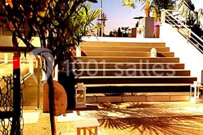 Salle de jeux lumineuse avec une cabane en tissu, un tapis de chiffres, une cuisine pour enfants et des tables colorées.