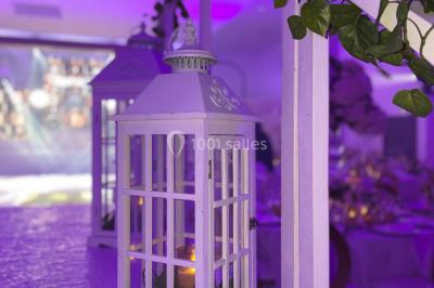 Salle de jeux lumineuse avec une cabane en tissu, un tapis de chiffres, une cuisine pour enfants et des tables colorées.