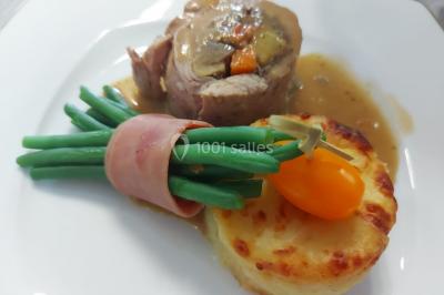 Salle de jeux lumineuse avec une cabane en tissu, un tapis de chiffres, une cuisine pour enfants et des tables colorées.