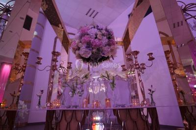 Salle de jeux lumineuse avec une cabane en tissu, un tapis de chiffres, une cuisine pour enfants et des tables colorées.