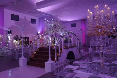Salle de jeux lumineuse avec une cabane en tissu, un tapis de chiffres, une cuisine pour enfants et des tables colorées.